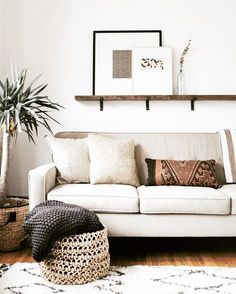 a living room filled with furniture and lots of pillows on top of a wooden floor