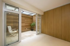 an empty room with wooden walls and sliding glass doors