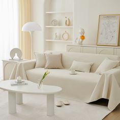 a living room filled with white furniture and decor