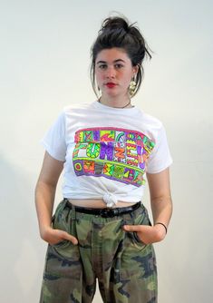 This is a funky 80s vintage summer graphic tee! It's a soft bright white, thin, semi sheer 50/50 t-shirt with a neon multicolor vinyl graphic that reads "Fun N Sun" in stylized letters. It has cool beachy, tropical and tribal imagery including a palm tree, surfboards, spirals, a sailboat and a graffiti MTV style face. Light and whimsical, and perfect for summer play in the surf, or the perfect retro gift for someone who misses California! This tee shirt is in very good clean freshly laundered condition, no flaws or wear noted. The label reads "Fun 'N Sun, Large, 50% Cotton, 50% Polyester, Made in USA." It may have been made as an oversized Youth Large, as it fits like an Adult Unisex size Small to Medium, and it measures: Chest - 36 inches, Shoulders - 17 inches, Sleeves - 6 inches, Length 1980s New Wave, Normal Fashion, California Surfer, Miss California, Summer Graphic Tee, Retro Gift, Beach California, Vintage Shorts, Vintage Summer