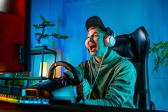 a man with headphones on sitting at a desk in front of a computer monitor