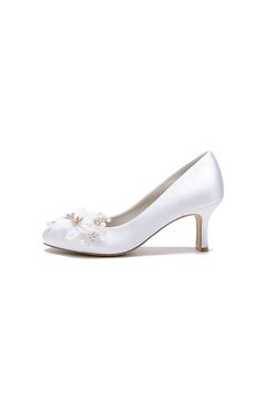 a woman's white wedding shoe with flowers on the toe and heels are shown