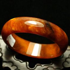 59mm Golden Yellow and White Clouds Hand-carved Natural Jade Bangle #A3 weight: 76.5g, 421.5 Ct Jade NameNatural Jade Item SizeInner diameter: 58 mm Width:17.6mm Thickness: 7.1 mm This unique bangle has lots of internal feature with clouds, silk streaks and wen. Inviting autumn color with this golden orange tawny with white flowers. This is a gorgeous and high quality jadeite bangle. Luxury Collectible Round Bangle, Luxury Round Amber Jewelry, Luxury Carved Bracelet Jewelry, Collectible Carved Round Jewelry, Elegant Brown Bangle For Formal Occasions, Elegant Formal Brown Bangle, Luxury Engraved Round Bangle, Elegant Carved Orange Jewelry, Luxury Carved Bangle Jewelry