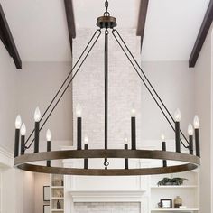 a large chandelier hanging over a fireplace in a living room with white walls