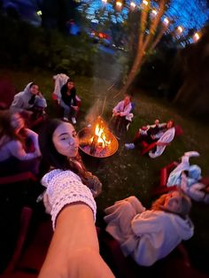 people sitting around a fire pit at night