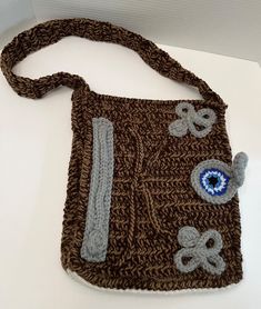 a crocheted brown purse with blue eyes on it