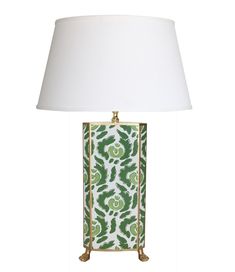 a green and white lamp with a white shade on the base, sitting next to a white lampshade