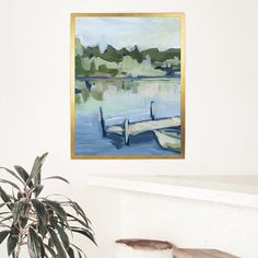 a painting hanging on the wall next to a potted plant in front of a fireplace