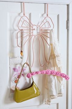 two purses hanging from hooks on a door