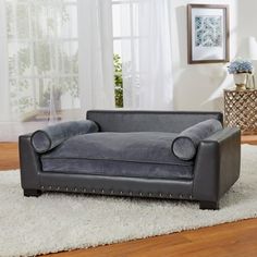 a gray couch sitting on top of a white rug