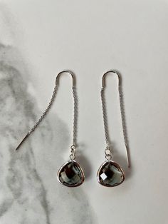 "Fine and delicate, these earrings flow from the earlobe in a beautiful silver line. Length can be adjusted depending how far the chain is pulled through the ear. These threader earrings measure 55mm in length. Hanging from one end of the chain is a beautiful faceted glass charm. Threader earrings come with wire ends to make it easy to thread the chain through any pierced hole of your ear, making these earrings fun to wear and play around with (from one pierced hole to another). Their versatilit Elegant Silver Threader Earrings For Gifts, Elegant Silver Long Drop Threader Earrings, Elegant Silver Threader Earrings, Elegant Sterling Silver Threader Earrings, Elegant Silver Sterling Threader Earrings, Gray Ear Wire Earrings For Gift, Elegant Sterling Silver Threader Earrings In Silver, Gray Drop Earrings For Gift, Elegant Nickel-free Gray Jewelry