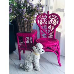 a pink chair with a dog figurine sitting next to it