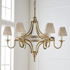 a chandelier with five lamps hanging from it's sides in a room