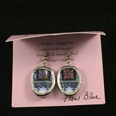 a pair of earrings sitting on top of a pink card