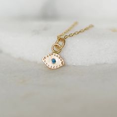 "Gold evil eye charm necklace in sparkly blue diamond and 14k gold. Handmade evil eye necklace set with a teal blue diamond center. The charm come-on a 1.3mm 14k gold chain with lobster clasp. This tiny gold charm is the perfect size for every day wear! Eve dimensions - 8mm wide x 5mm tall (without bail) diamond - 1.7mm teal blue diamond (treated to enhance color) chain - adjustable between 16-18\", 1.3mm cable chain with lobster clasp **Please note the photos are enlarged on your computer scree Blue Jewelry For May Birthstone Gift, Blue Jewelry Gift For May Birthstone, Blue May Birthstone Jewelry For Gift, Everyday Blue Necklace With Charms, Everyday Blue Necklaces With Charms, Everyday 14k Gold Turquoise Jewelry, Dainty Blue Birthstone Necklace For Everyday, Everyday Turquoise 14k Gold Jewelry, Blue Round Pendant Jewelry For May Birthstone