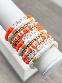 UNIVERSITY OF TENNESSEE stackable friendship bracelets. Perfect for game days or every day!  Bracelets are made with Heishi (clay) beads, 18k gold filled spacer beads, & gold plated brass spacer and barrel beads.   Each bracelet sold separately*  INSTRUCTIONS: 1. Measure your wrist and select size from drop down menu. (See photo for measurement instructions.) 2. Select which bracelet(s) you want to purchase from the "BRACELET OPTIONS" drop down menu.  3. Complete the "PERSONALIZATION" Section if you would like to make any changes.  📦📫FREE SHIPPING ON ALL DOMESTIC ORDERS OF $35 OR MORE! 📌Care:  Keep bracelets dry and away from chemicals. Roll bracelet on instead of stretching over hand. Bracelets may break with excessive over-stretching. 📌Since each bracelet is made to order, all sales Adjustable Multicolor Beaded Bracelets For Game Day, Adjustable White Friendship Bracelets For Game Day, Stacked Adjustable Beaded Bracelets For Friendship, Adjustable Stacked Beaded Bracelets For Friendship, Keep Bracelet, Bracelets Bead, Layering Bracelets, Tennessee Vols, College Graduation Gifts