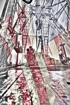 a ferris wheel is reflected in the reflection of it's glass window as people watch