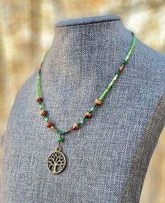 "Authentic Native American, handmade, Cedar Juniper Berry seed and Tree of Life pendant necklace. Cedar beads, colorful glass seed beads (size 11/0), round silver beads (6 mm) and a charm are strung with jewelry wire and closed with lobster claw clasp. Charm design is the same on both sides. Navajo legend says Cedar beads, also known as \"Ghost Beads,\" will keep evil spirits and bad dreams away. For example, it is customary for Navajo mothers to place strung cedar beads on/near their traditiona Handmade Hippie Green Beaded Necklaces, Bohemian Czech Glass Beaded Necklace With Tiny Beads, Spiritual Colorful Beaded Necklaces, Hippie Green Jewelry With Colorful Beads, Adjustable Spiritual Beaded Necklaces With Metal Beads, Bohemian Nickel-free Beads For Gifts, Earthy Adjustable Beaded Necklace With Round Beads, Hippie Style Beaded Necklaces With Gemstone Beads, Bohemian Nickel-free Beaded Necklaces