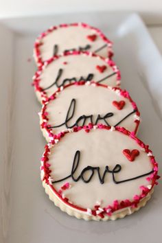 three decorated cookies with love written on them