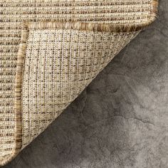 a close up view of the woven material on top of a tablecloth with grey background