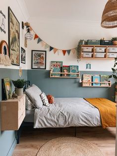 a bed room with a neatly made bed and lots of pictures on the wall above it