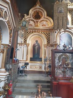 the interior of an old church with candles in front of it and paintings on the walls