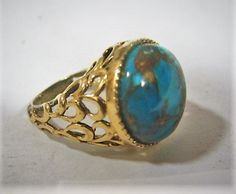 Deep color turquoise cabochon round stone,  in silver vermeil reticulated setting.Size 7.Cabochon is fairly deep and measures approximately 18 cm in diameter.  The color is a deep rich turquoise and has brownish gold matrix.Nice delicate silver work, with gold finish.Signed 925 China.Very attractive ring, the stone sits high and is complimented by the gold vermeil.Good condition, gold is worn at back of band, visible in photos.Please see all photos and email any questions.Shipping via USPS. Vintage Silver Jewelry, Color Turquoise, Silver Work, Onyx Ring, Deep Colors, Ring Size 7, Gold Style, Sterling Ring, Unique Rings