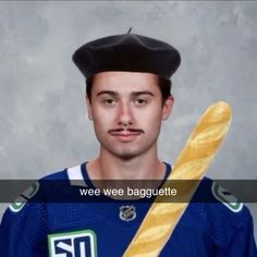 a man in a hockey uniform holding a large loaf of bread with the words wee wee baguette on it