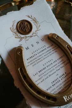 a close up of a paper with a horse shoe on it and a menu in the background