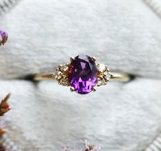 a ring with an amethyst purple stone surrounded by flowers