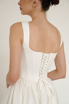 the back of a woman wearing a white wedding dress