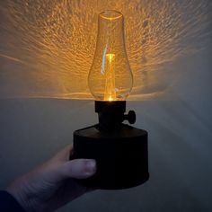 a hand holding a light that is on top of a table