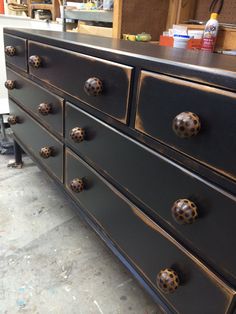 a black dresser with lots of knobs on it