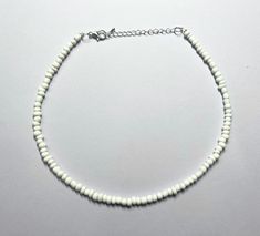 This beautiful necklace is handmade with large white seed beads. It comes in multiple different sizes (14, 16, 18, 20, 22, and 24 inches), ranging from a choker fit to a longer necklace. Every necklace from my shop also comes with additional extender chain, making it easily adjustable. Message with any questions or personalization requests! White Beaded Choker For Summer, Adjustable White Beaded Chain, White Tiny Beads Choker For Summer, White Summer Choker With Tiny Beads, Summer White Choker With Tiny Beads, Adjustable White Choker For Festival, Summer White Beaded Necklaces With Spacer Beads, White Round Beads Choker For Beach, White Beaded Chain Bracelets For Summer