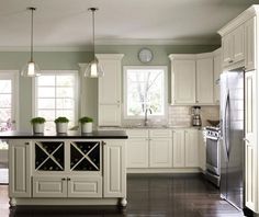 a large kitchen with white cabinets and black counter tops, along with an island in the middle