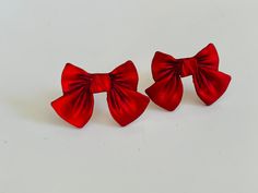 These red bow stud earrings have a velvety,satiny look to them. They are made of resin and have sterling silver posts. They measure approximately 1/2 an inches Your earrings will arrive packaged and ready for gifting. Red Christmas Earrings For Formal Occasions, Red Earrings For Christmas Formal Events, Red Earrings For Christmas Formal Occasion, Elegant Jewelry With Red Bow For Gifting, Red Christmas Jewelry, Bow Earrings For Valentine's Day Gift, Elegant Earrings With Satin Bow For Gift, Elegant Earrings With Satin Bow As Gift, Valentine's Day Party Jewelry With Red Bow