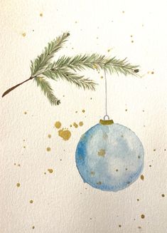 a watercolor christmas ornament hanging from a tree branch