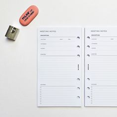 an orange pill next to a white notebook with writing on it and a metal stapler