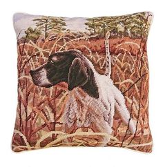 a brown and white dog sitting on top of a pillow in the middle of a field