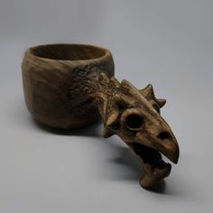 a wooden cup with a carved dragon head on it