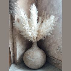 a vase with some white flowers in it on a table next to a wallpaper