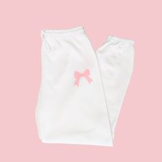 🛒Introducing the Pink Bow Soft Girl Era Sweatpants, the perfect mix of comfort and style! With an elastic waistband, these preppy sweats pants will keep you on-trend while still feeling cozy. Embrace the coquette trend with these trendy lounge pants. 📦FREE SHIPPING on orders $35 or more to US shoppers 👕Brand = Gildan 🧵Fabric = 50% Cotton / 50% Polyester ✂️Design = Blush Pink heat-applied vinyl 🎨Color = White -Colors will vary from computer to computer and monitor to monitor. -The colors shown may not be an exact representation. -Slight shade variations of garment colors are likely in the pigment dye process. 📏Sizing = Unisex -Please see size chart in photos -Sweatpants have more of an oversized fit -Drawstring elastic waistband, elastic cuffs and no pockets -Model is 5'0 and wearing Cute White Pants With Elastic Waistband, Cotton Sweatpants With Elastic Waistband For Sleepover, Cute Pink Cotton Pants, Pink Cotton Sweatpants For Pajama Party, Cute White Bottoms With Elastic Waistband, Cute White Pants For Sleepover, Cute Bottoms With Elastic Waistband, Cute Loungewear Pants With Elastic Waistband, Cute Cotton Pants With Elastic Waistband