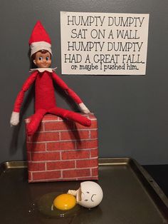 an elf is sitting on top of a brick wall with eggs in front of it