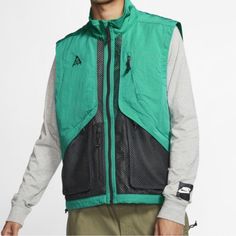 New Without Tags Size Large Men’s Color Neptune Green Black The Nike Acg Gilet Mixes Lightweight Weather Resistance With A Functional Design. A Mix Of Breathable And Woven Fabrics Helps Keep You Cool And Comfortable, While Multiple Pockets Ensure Your Essentials Are Close At Hand. Functional Comfort The Gilet's Material Mix Is All About Comfort. Woven Fabric On The Upper Portion Keeps You Covered With Lightweight Water Resistance. Mesh Throughout The Bottom Helps Keep Things Breathable And Cool Streetwear Green Sport Coat With Pockets, Green Sport Coat With Pockets For Streetwear, Urban Sport Coat With Pockets For Outdoor Activities, Green Utility Outerwear For Hiking, Casual Sport Coat With Pockets For Hiking, Urban Green Outerwear For Hiking, Urban Track Jacket With Pockets For Hiking, Urban Hiking Track Jacket With Pockets, Spring Techwear For Hiking