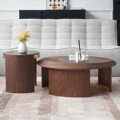 two coffee tables sitting next to each other on top of a carpeted floor in front of a white couch