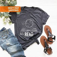 Read Shirt, Reading Shirt, Reading T-Shirt, Reading Week Teacher Shirt, Librarian Shirt, Book Lover Shirt, Book T shirt, Teacher Shirts  BLACK TEXT is used for Yellow, Heather Peach, White, Light Gray Heather, Mint, Pink Shirts. Other colored shirts have white text. F I T ∙ & ∙ S I Z I N G : -->Women's sizes are narrower than the waist. -->Sleeves are rolled up in some product pictures. They do not come rolled up on delivery. T I M E ∙ T O ∙ D E L I V E R Y : -->Processing and production time is Bookish Cotton T-shirt With Letter Print, Screen Print Short Sleeve Tops, Literary Style Short Sleeve Screen Print Tops, Literary Black Cotton T-shirt, Bookish Letter Print T-shirt For School, School T-shirt With Letter Print In Bookish Style, Cotton Slogan T-shirt, Cotton Bookish Slogan T-shirt, Bookish Text Print Tops For School