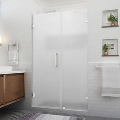 a bathroom with a sink, mirror and shower stall