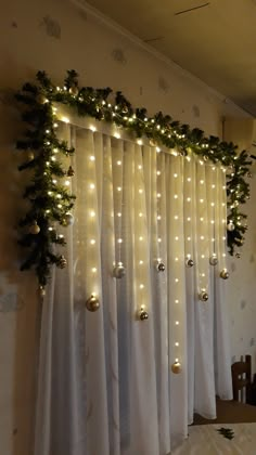 the curtain is decorated with lights and greenery