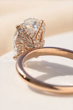 an engagement ring with a pear shaped diamond surrounded by smaller diamonds