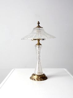 a glass lamp sitting on top of a white table